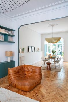 a living room filled with furniture next to a dining room table and bookshelf