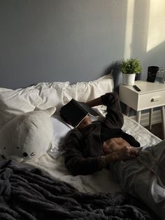 a man laying on top of a bed next to a white teddy bear