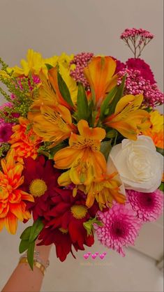 a person holding a bouquet of flowers in their hand