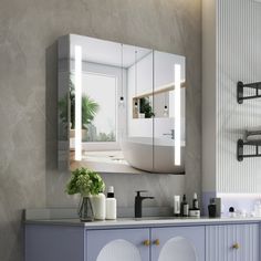 a bathroom with a sink, mirror and other items on the counter in front of it