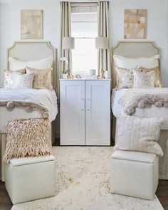 two white beds in a bedroom next to each other