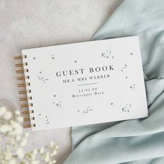 the guest book is sitting on top of a blue sheet with baby's breath