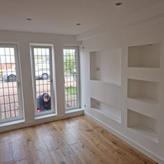 an empty room with three windows and no one in the house or someone is looking out