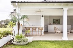 an outdoor kitchen and dining area with palm trees