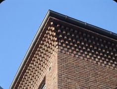 the corner of a brick building with a clock on it