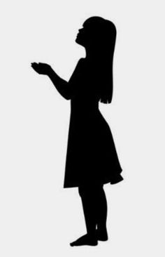 the silhouette of a woman standing in front of a white wall with her hand out