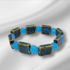 Finish Your Look With This Stretch Bracelet. It Consists Of Raku Ceramic Beads Features Are Lat Square Blue, Green Splatters, And Opaque Aqua Faceted Glass Beads. It Has A Secure It. Bracelet Measurements - 7 3/4inches Or 19.7cm Dimension: * Raku Ceramic Beads ( Lat Square Blue-Green Splatters) * Opaque Aqua Faceted Glass Beads ( 10 Mm) * Clear Elastic Cord (1mm) Blue Czech Glass Beaded Bracelets With Round Beads, Blue Czech Glass Beaded Bracelets, Blue Czech Glass Beaded Crystal Bracelet, Casual Blue Bracelets With Large Beads, Turquoise Czech Glass Beaded Bracelet With Faceted Beads, Handmade Blue Stretch Bracelet In Czech Glass, Handmade Blue Stretch Bracelet With Czech Glass, Handmade Blue Czech Glass Stretch Bracelet, Casual Blue Jewelry With Large Beads