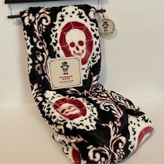 a scarf with a skull on it hanging from a hook in front of a white wall