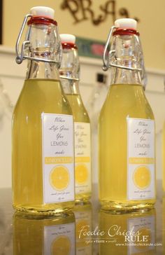 three bottles of lemonade sitting on top of a counter