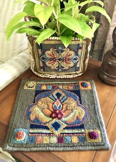 a potted plant sitting on top of a wooden table next to a blue rug