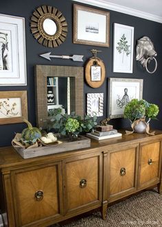 a living room with pictures on the wall and a wooden dresser in front of it