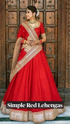 a woman in a red and gold bridal gown standing next to a wooden door