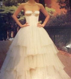 a woman in a white dress posing for the camera