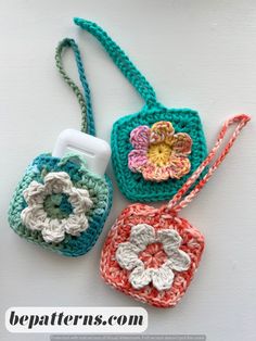 three crocheted purses sitting on top of a white table next to each other