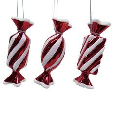 three red and white ornaments hanging from strings