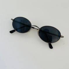 These mini oval sunglasses are your everyday classic. Featuring a silver metal frame with black lens. This style is unisex. True genuine vintage sunglasses from the 90s.  - 400 uv  - new vintage from the 90s - includes sunglasses pouch Vintage Oval Sunglasses, 90s Sunglasses Vintage, 90s Accessories, Black Skirt Outfits, 90s Sunglasses, Small Sunglasses, Sunglasses Pouch, Sunglasses Frame, Stylish Glasses