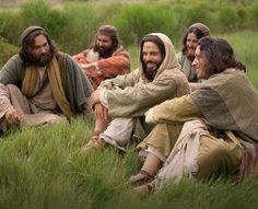 several people are sitting in the grass together