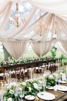 the tables are set with white linens and greenery for an elegant wedding reception