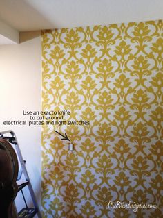 the wall is painted with yellow and white damask pattern, which has an arrow pointing to