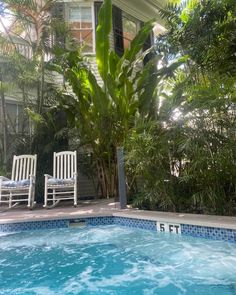 an empty swimming pool with two chairs next to it