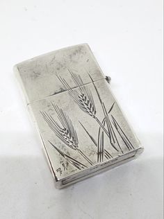 a silver flask with wheat design on it