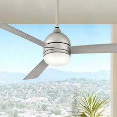 a ceiling fan with a light on top of it in front of a large window