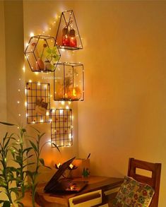 a table with some plants on it and lights hanging from the wall behind it in front of a potted plant