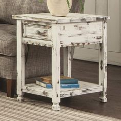 a white end table with books and a potted plant sitting on top of it