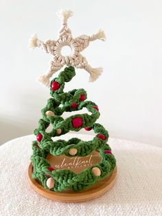 a crocheted christmas tree on top of a wooden stand