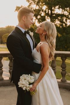 a bride and groom are standing together outside