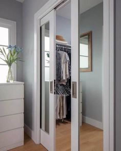 a closet with mirrored doors and white drawers