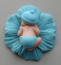 there is a blue and pink brooch with a baby in it's diaper