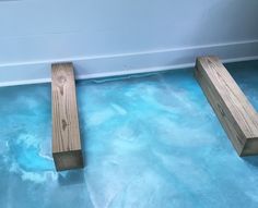 two wooden benches sitting on top of a blue floor