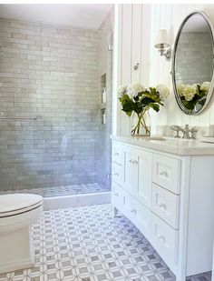 a white bathroom with gray and white tile