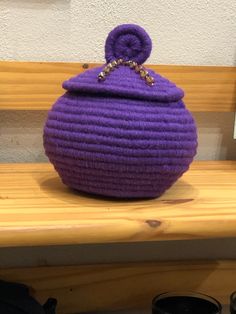 a purple purse sitting on top of a wooden bench