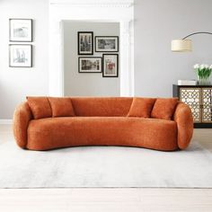 an orange couch sitting on top of a white rug