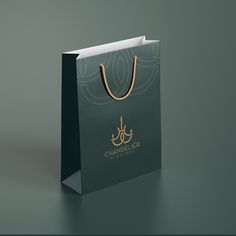 a black shopping bag with a gold handle and handles on the front that says chandelier in arabic