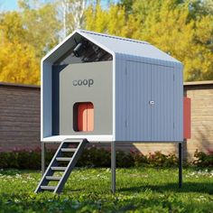 an outdoor toilet in the grass with a ladder up to it's roof and door open