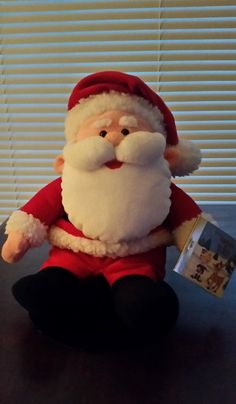 a stuffed santa clause sitting on top of a table