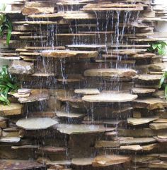 an outdoor waterfall with rocks and water cascading