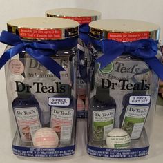 two bottles of dr teal's products with blue bows on them are sitting next to each other