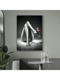 a black and white photo of a woman's legs with a glass of wine