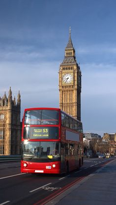 a red double decker bus driving past big ben