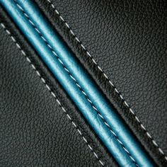 a close up view of the stitchs on a black leather material with blue lines