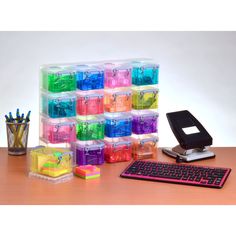 there is a computer keyboard and many plastic containers on the desk