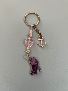 a keychain with an anchor, heart and pink jelly charm on the end