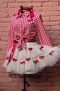 a red and white checkered dress with bows on the collar, long sleeves, and tulle skirt