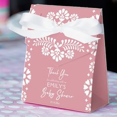 a pink gift bag with a white ribbon tied around it