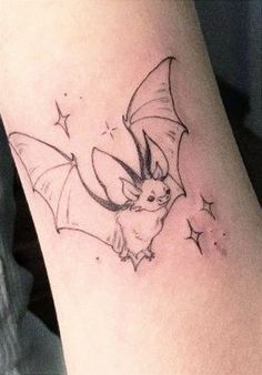 a small bat tattoo on the right arm and leg, with stars in the background