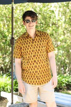 Our Amber Amer Men's shirt is so super soft and such a great colour combination. We have named it after the Amer Fort in Jaipur where this shirt is made. Block printers in Jaipur have practiced this art for centuries. This shirt will be a favourite for the summer! 100% cotton Wash cold, hang dry. Made in India This fabric is block printed by hand so slight variations in printing may exist which demonstrate the hand made aspect of this product. Cotton Ikat Print Short Sleeve Top, Traditional Cotton Shirt For Festive Season, Festive Yellow Cotton Top, Traditional Printed Yellow Tops, Casual Cotton Shirt For Festive Occasions, Casual Short Sleeve Kurta For Festive Occasions, Traditional Kalamkari Print Tops For Summer, Traditional Kalamkari Tops For Summer, Festival Printed Short Sleeve Shirt